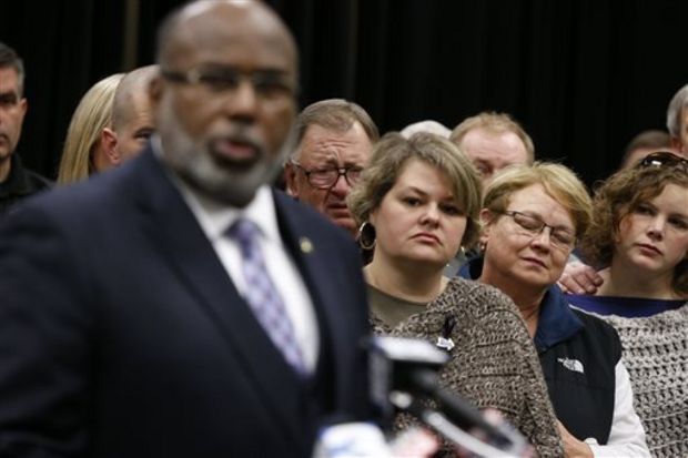 Beth Stauffer, center, reacts on Sunday, Dec. 29, 2013, as FBI Special Agent in Charge Danile McMullen announces they believe the bank robber who killed her husband, Sgt. Gale Stuaffer on Monday, was killed attempting another bank robbery in Phoniex, Ariz., on Saturday in Tupelo, Miss. (AP Photo/Northeast Mississippi Daily Journal, Thomas Wells)