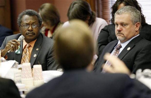 House Education Committee Chairman John Moore, R-Brandon, with back to camera, explains elements of his Teacher Pay Raise legislation to House Appropriations Committee members Charles Busby, R-Pascagoula, right, and Willie Perkins, D-Greenwood., Tuesday, Feb. 4, 2014 at the Capitol in Jackson, Miss. Lawmakers were facing a deadline for their committees to report general bills originating in their own chamber. (AP Photo/Rogelio V. Solis)
