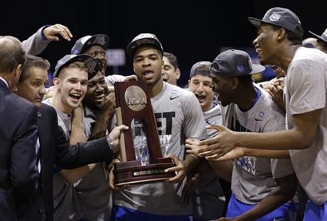 Kentucky's Aaron Harrison and his teammates hold up their trophy after an NCAA Midwest Regional final college basketball tournament game against Michigan Sunday, March 30, 2014, in Indianapolis. Kentucky won 75-72 to advance to the Final Four. (AP Photo/David J. Phillip)