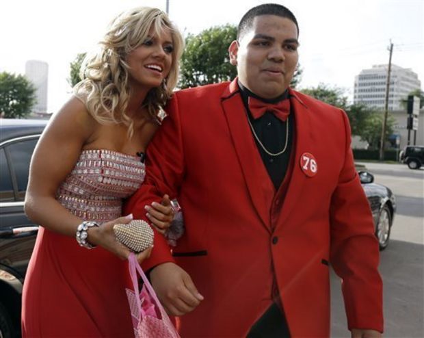 High school student Michael Ramirez, right, and Houston Texans cheerleader Caitlyn pose for pictures outside a restaurant before attending the prom Saturday, May 10, 2014, in Houston. Ramirez sent Caitlyn a Twitter message saying “If I get 10,000 retweets will you go to prom with me (insert smiley face.) you will get asked in a cute way!” He did and so she said yes. (AP Photo/Pat Sullivan)