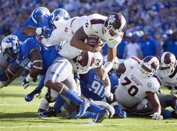 Mississippi State quarterback Dak Prescott dives into the end zone for a touchdown during the first half of an NCAA college football game against Kentucky at Commonwealth Stadium in Lexington, Ky., Saturday, Oct. 25, 2014. (AP Photo/David Stephenson)