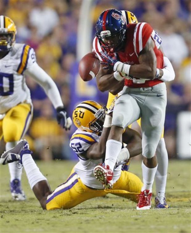 Mississippi running back I'Tavius Mathers fumbles as he is tackled by LSU linebacker Kendell Beckwith (52) and another defender during the first half of an NCAA college football game in Baton Rouge, La., Saturday, Oct. 25, 2014. Mathers recovered the ball. (AP Photo/Jonathan Bachman)