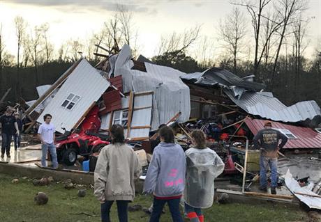 People examine a barn owned by the Miller family that was destroyed during a storm south of Mount Olive, Miss., Monday, Jan. 2, 2017. Forecasters say damaging winds, hail and flash flooding will be possible on Monday as a storm system moves across the South. (Ryan Moore/WDAM-TV via AP)