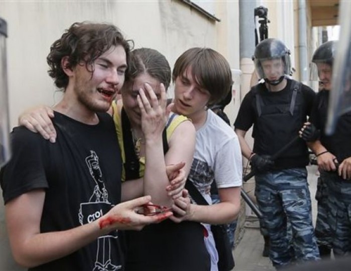 Riot police (OMON) guard gay rights activists who have been beaten by anti-gay protesters during an authorized gay rights rally in St.Petersburg, Russia, Saturday, June 29, 2013. Police detained several gay activists, who were outnumbered by the protesters. Dozens of gay activists had to be protected by police as they gathered for the parade, which proceeded with official approval despite recently passed legislation targeting gays. This image was chosen by the Associated Press as one of the top 10 news photos representing the top stories of 2013. (AP Photo/Dmitry Lovetsky, File)