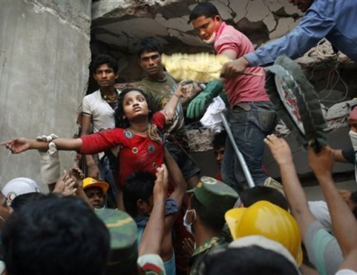 A Bangladeshi woman survivor is lifted out of the rubble by rescuers at the site of a building that collapsed Wednesday in Savar, near Dhaka, Bangladesh, Thursday, April 25, 2013. This image was chosen by the Associated Press as one of the top 10 news photos representing the top stories of 2013. (AP Photo/Kevin Frayer, File)