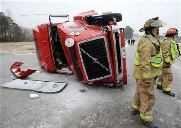 Hattiesburg firefighters work the scene of a two-vehicle accident in the northbound lanes of U.S. 49 off of U.S. 98 in Hattiesburg Miss.,Tuesday, Jan. 28, 2014. Icy roads were the cause of the accident that sent one person to the hospital with non-life threatening injuries.( AP Photo/Hattiesburg American, Ryan Moore