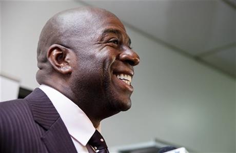 Businessman and former NBA star Magic Johnson smiles while speaking to members of the media during a press conference Tuesday, April 29, 2014, in Saginaw, Mich. Johnson spoke about Los Angeles Clippers owner Donald Sterling, whom NBA Commissioner Adam Silver banned for life from the league on Tuesday. (AP Photo/The Saginaw News, Neil Barris)