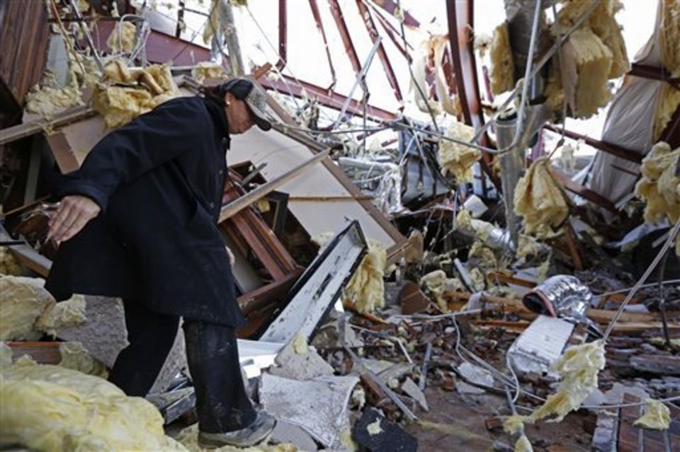 Sandra McDaniel walks through the remains of the product showroom for Jack Morris Gas Company in Columbia, Miss., Wednesday, Dec. 24, 2014. The community was hard hit by a tornado on Tuesday that destroyed several businesses and homes and have two deaths attributed directly to it. (AP Photo/Rogelio V. Solis)