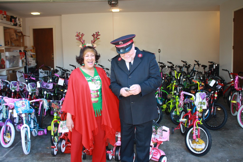 Caroyln Meyers and Captain Ken Chapman, area commander of the Salvation Army, laugh while standing in front of the donated bikes.