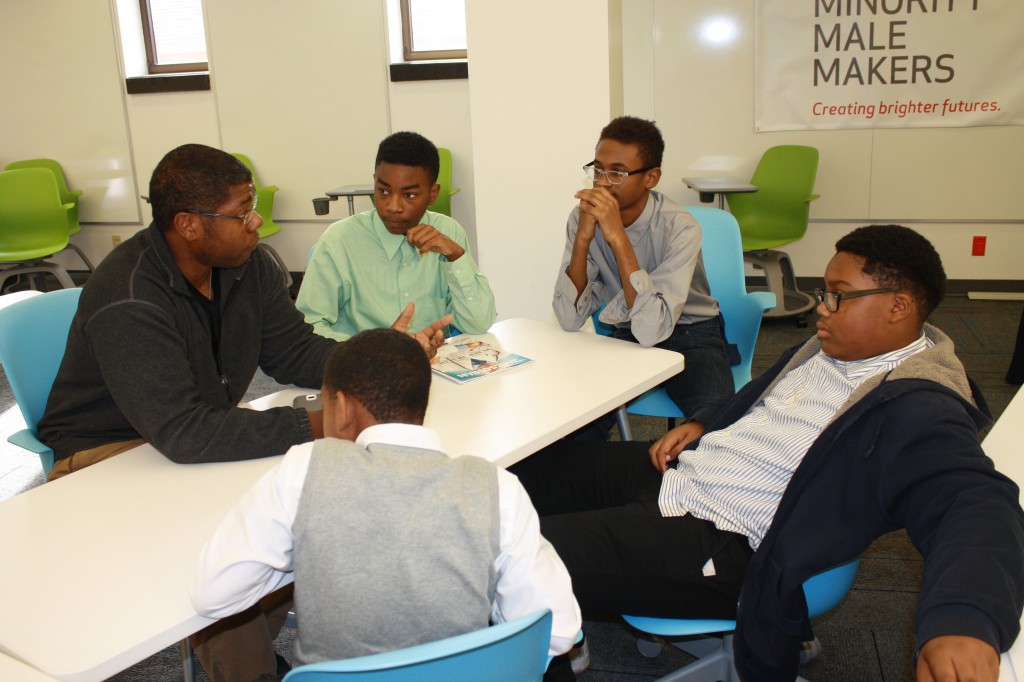 Eric Johnson, a mentor from the summer program, talks with Blackburn students about their business idea before pitching it to Kevin Liles. Students are (from left) Jamarious Stewart, Dakari Ceaser, Prae McGee, and Tavorris Lenoir. Photo by Shanderia K. Posey