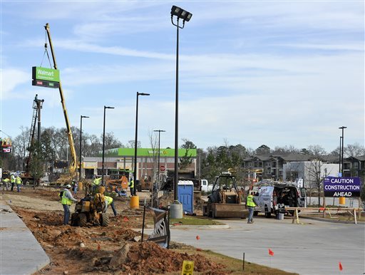 One crew finishes up landscaping as a second crew installs the primary sign on top of a pole, Friday, Jan. 15, 2016, at a new Wal-Mart Neighborhood Market location slated to open soon in Tyler, Texas. Even as the Bentonville, Ark., based company plans to open three stores in Tyler, the company announced Friday the planned closure of 269 stores, more than half of them in the U.S. and another big chunk in its challenging Brazilian market. (Andrew D. Brosig/Tyler Morning Telegraph)