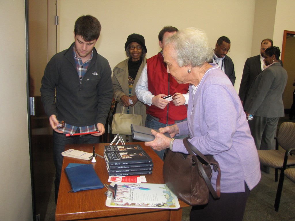 Retired professor and chair of Jackson State University’s Department of English, Mabel Pittman, selects a book to be signed by Sen. David Jordan. PHOTO BY JANICE K. NEAL-VINCENT