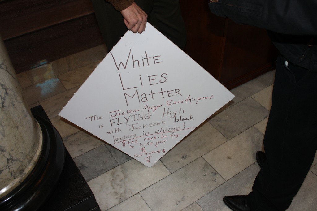 An Coalition for Economic Justice supporter’s sign was on display at the press conference. PHOTO BY SHANDERIA K. POSEY