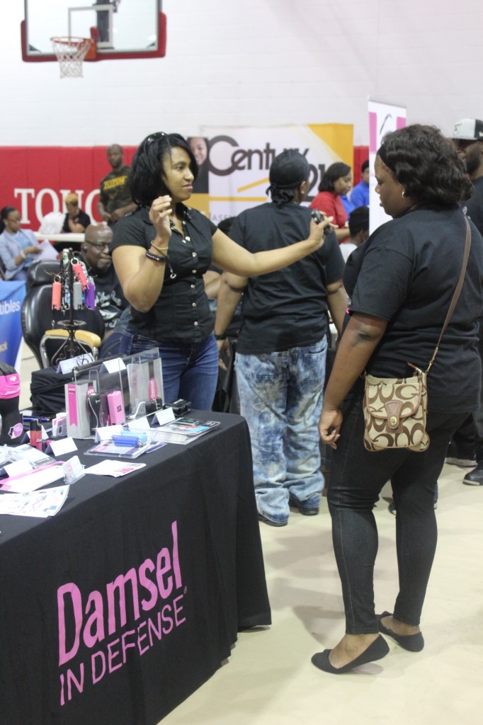 Latisha Holmes of Damsel in Defense demostrates a product to a customer. Photo by Diamond Williams