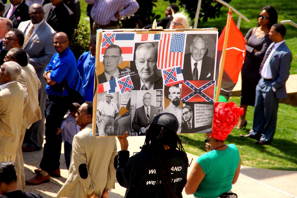Rally participants display anti-Confederate flag poster during the event. PHOTO BY JAY JOHNSON