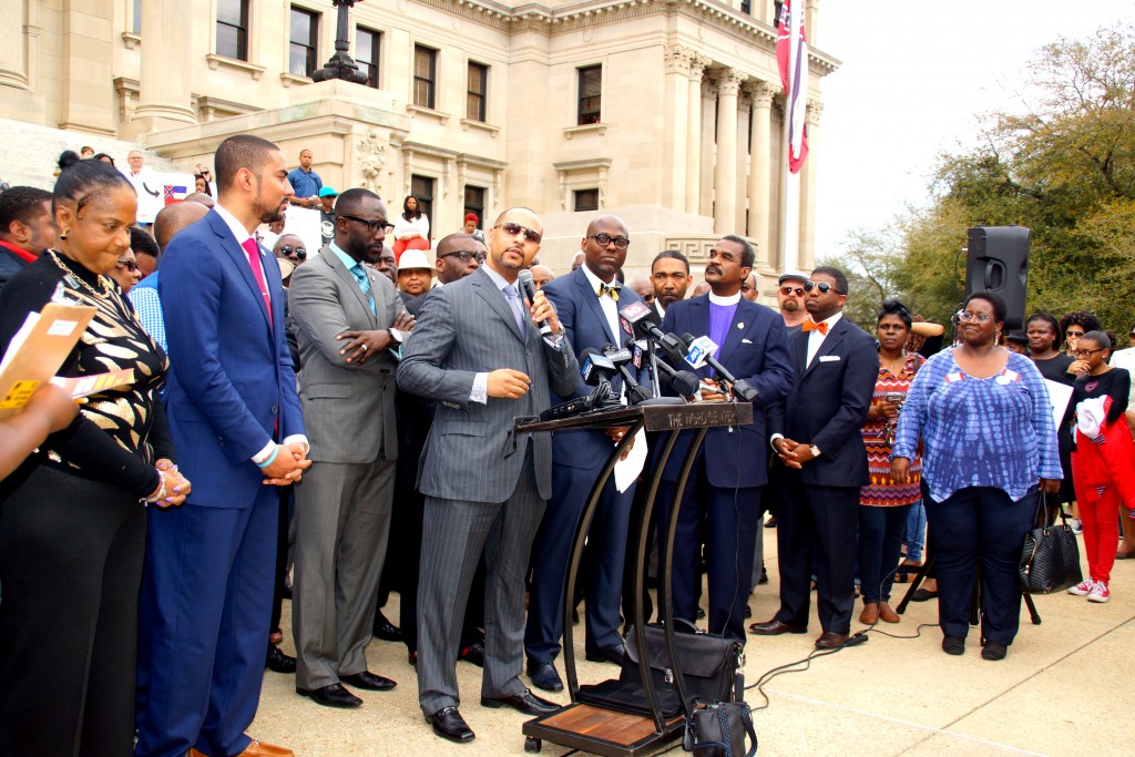 Carlos Moore, (at podium) addresses the crowd during the rally. With him are Rep. Justin Bamberg - S.C., (from left), Jackson Mayor Tony Yarber, Pastor Jamal Bryant and Attorney J. Wyndal Gordon. PHOTO BY JAY JOHNSON