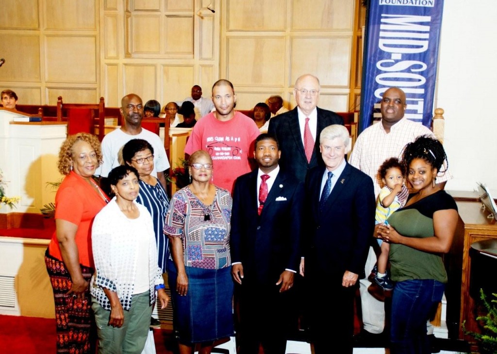 Helm Place residents stand with Rev. C.J. Rhodes (center), Gov. Phil Bryant (right) and Clarence Chapman of Chartre Consulting (back row with tie). PHOTO BY JAY JOHNSON