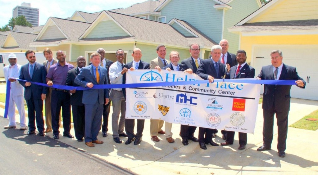 Rev. C.J. Rhodes, pastor of Mount Helm Baptist Church, and Gov. Phil Bryant cut the ribbon for the official opening of Helm Place July 14, in downtown Jackson. Standing with them are several local and national dignitaries involved in the development.  PHOTO BY JAY JOHNSON