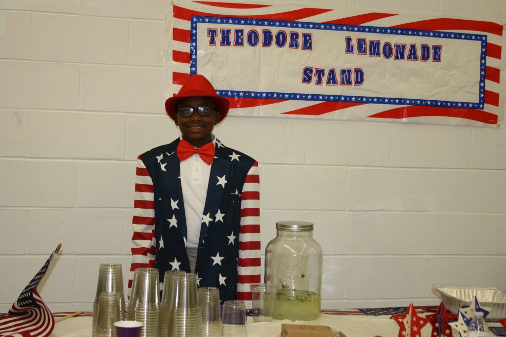 Theodore Carter, 10, operates his lemonade stand during the presidential debate watch party Sept. 26. 