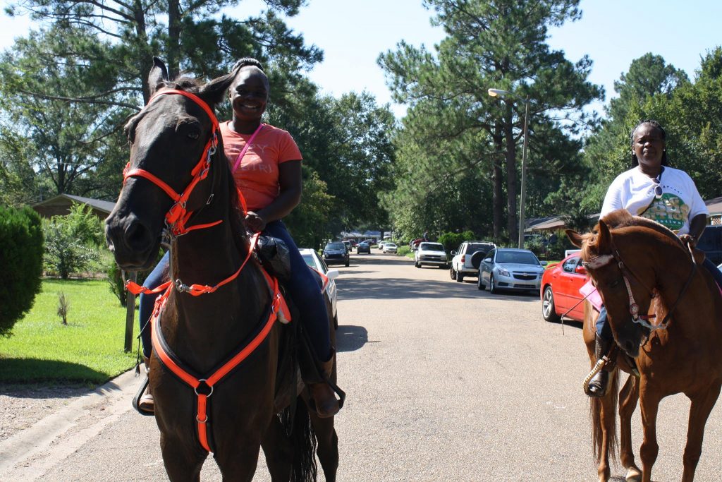 Tina Hobson and Janice Walker ride horses during the community day activities.