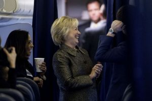 Democratic presidential candidate Hillary Clinton laughs aboard her campaign plane with Senior Policy Advisor Maya Harris, left, and other staff members in White Plains, N.Y., Sunday, Oct. 2, 2016. (AP Photo/Andrew Harnik)