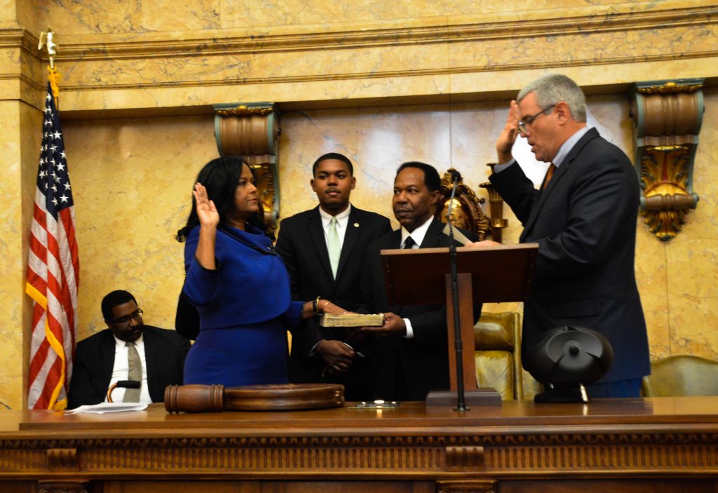 Family members of Debra Gibbs stand by her side as Speaker of the House Philip Gunn leads Gibbs in the oath of office.