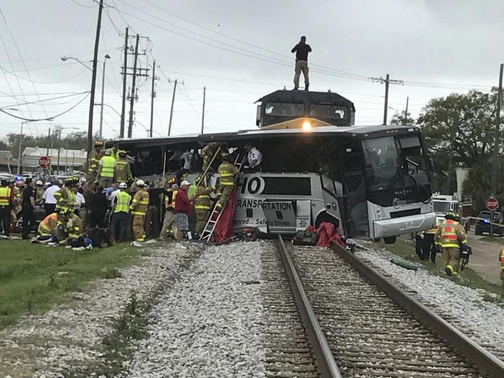 Biloxi firefighters assist injured passengers after their charter bus collided with a train in Biloxi, Miss., Tuesday, March 7, 2017.  Biloxi city spokesman Vincent Creel says emergency responders were still removing injured people from the bus more than 30 minutes after the crash. (John Fitzhugh/Sun Herald via AP)
