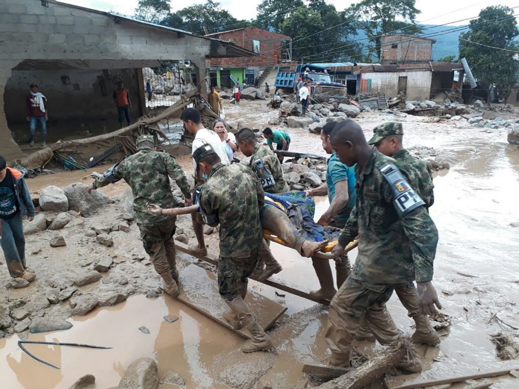 In this handout photo released by the Colombian National Army, soldiers carry a victim on a stretcher, in Mocoa, Colombia, Saturday, April 1, 2017, after an avalanche of water from an overflowing river swept through the city as people slept. (Colombian Army Photo via AP)