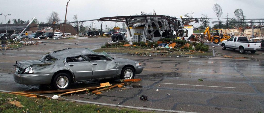 A demolished car sits across from what remains of a shell gas station in Tupelo, Miss., after a tornado touched down Monday, flattening homes and businesses. (JIM LYTLE/AP)