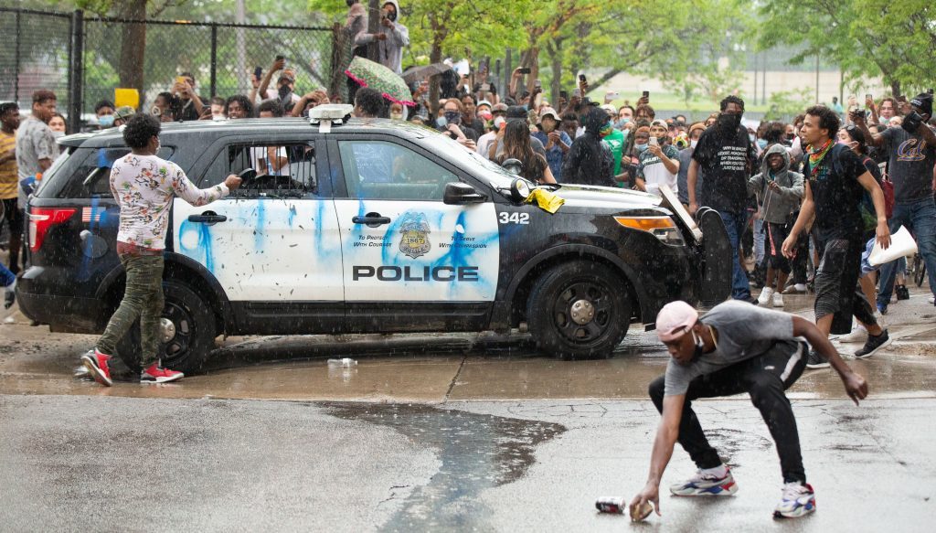 During a protest over the police killing of George Floyd, protesters gather in the back of the precinct where some of the protesters picked up rocks and medal objects to smash the windows of a squad car in the back on May 26, 2020. (Chris Juhn/Zenger)