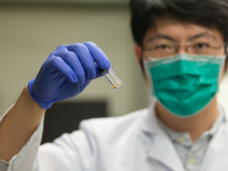 University of Cincinatti researcher Tianyu Zhang holds a vial of grapheme used as a catalyst to convert carbon dioxide to methane. (Andrew Highley, U. Cincinatti)