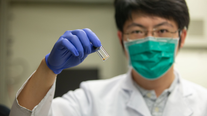 University of Cincinatti researcher Tianyu Zhang holds a vial of grapheme used as a catalyst to convert carbon dioxide to methane. (Andrew Highley, U. Cincinatti)